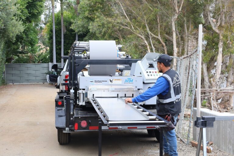 Infinity Roofers crew forming standing seam metal roof panels on site in Malibu