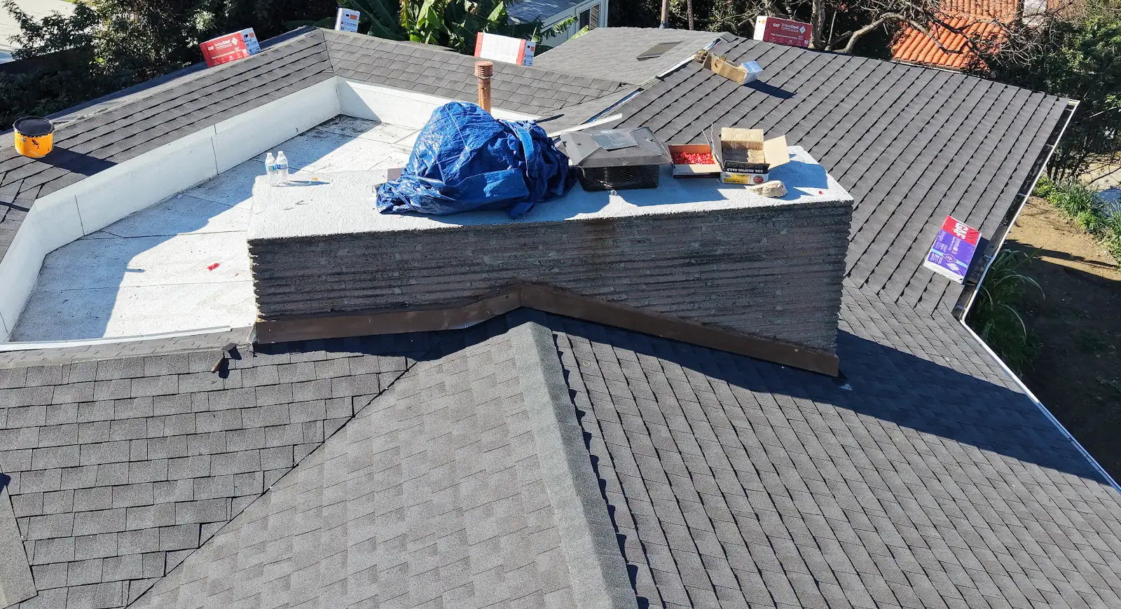 Tarp protecting an opening on a shingle roof before repair
