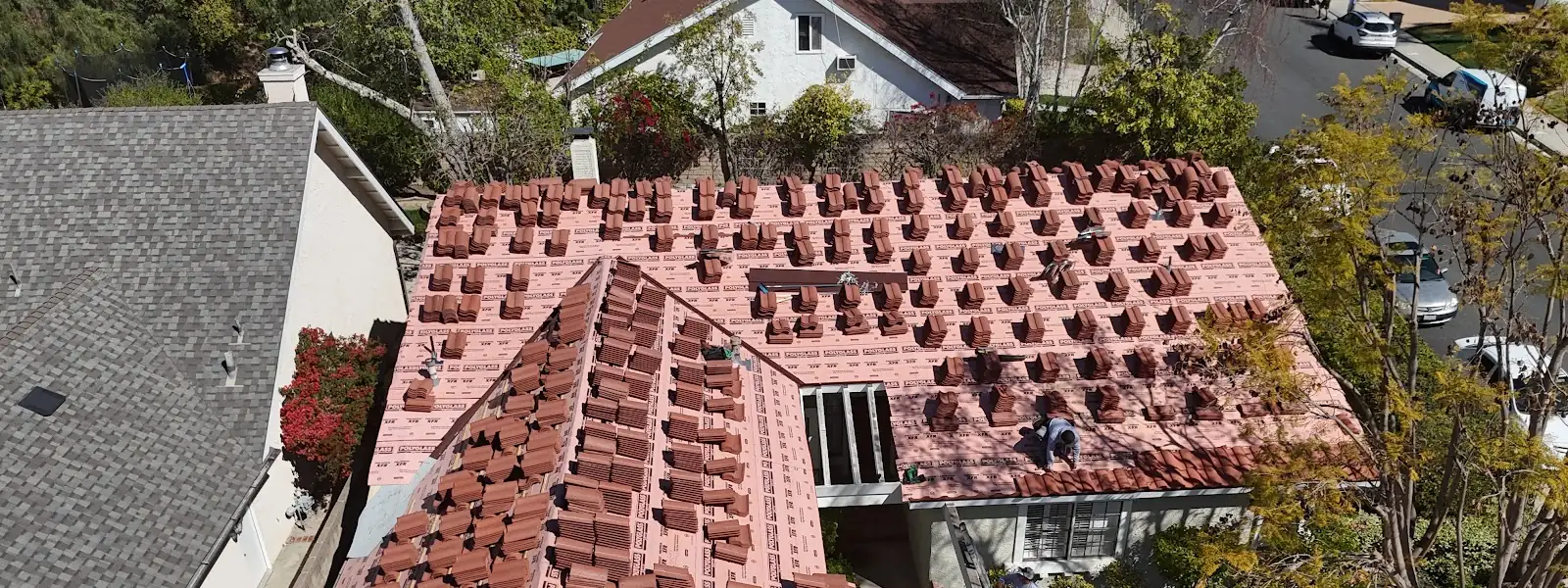 Clay tile staged on new underlayment during a tile reroof by Infinity Roofers